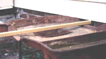 Detail of bar that is held high above the fire, resting on sides of forge hearth.
